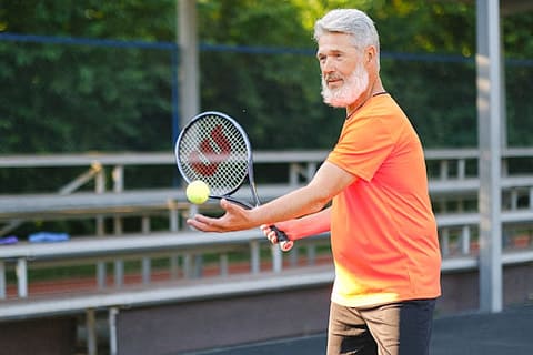 senior playing tennis